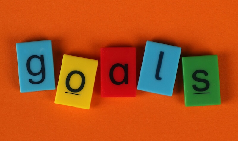 Image of brightly colored tiles that spell out the word "goals".