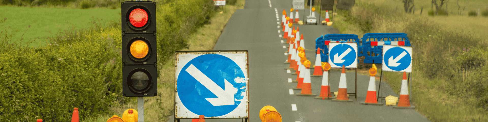 Image of road work with road signs, cones, and stop lights