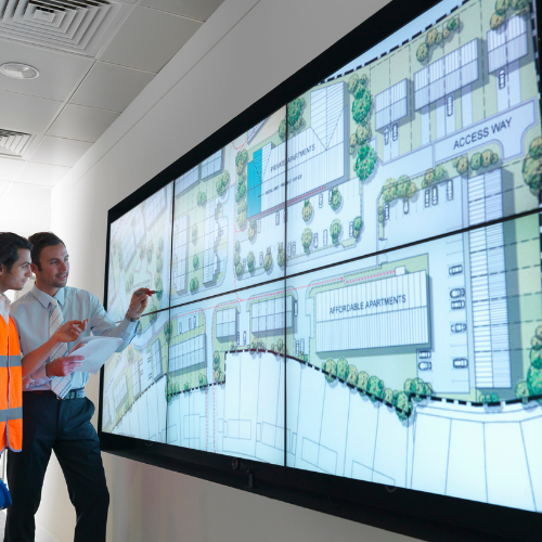 Public Sector Leaders discussing strategic planning in front of large screen of city plan