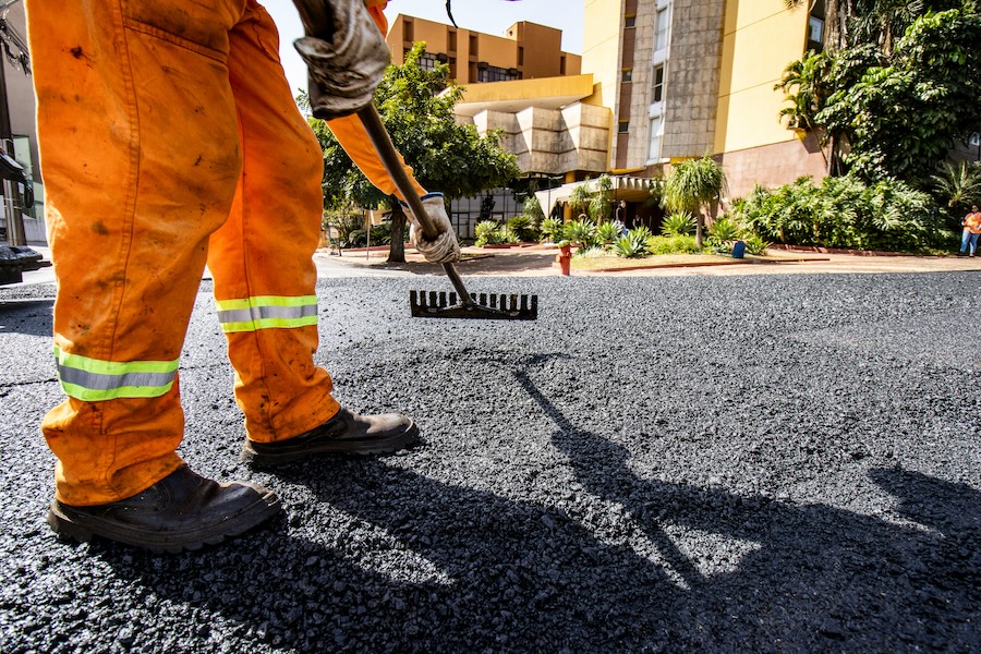 Image showing the legs of a public works person smoothing out a new road, to denote how government strategic planning software can help cities and counties complete plans and projects.