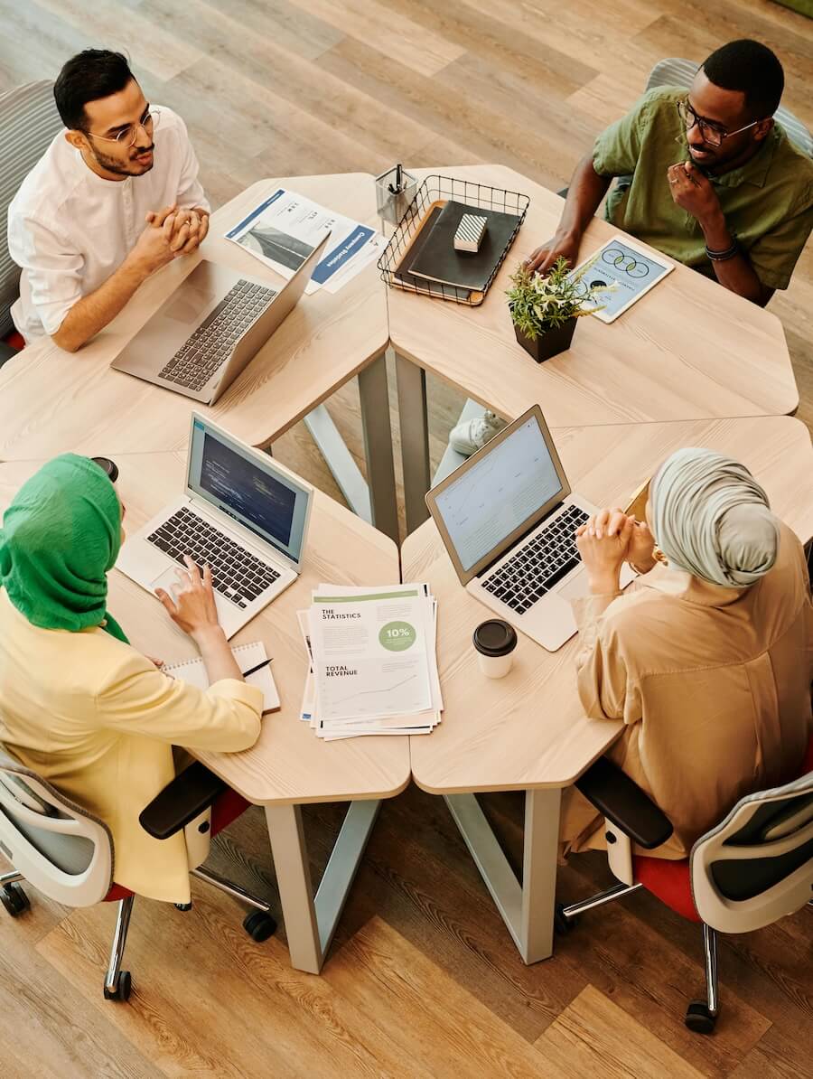 Photo of four people sitting around a table having a meeting.