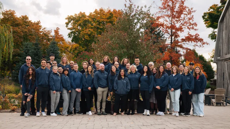 Envisio team standing together with autumn trees in background