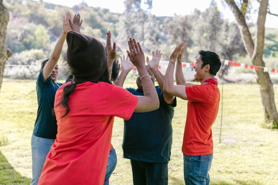 Photo of people high-fiving in a park.