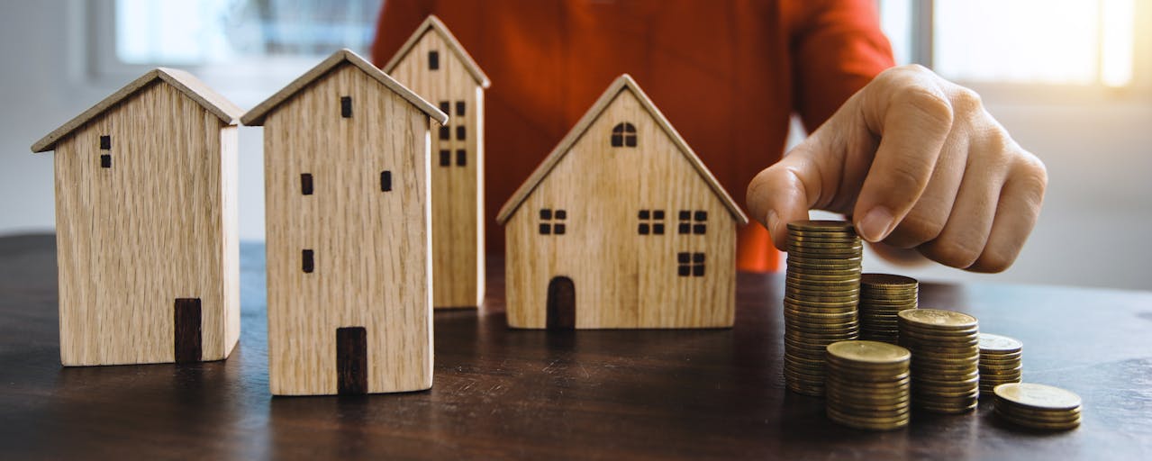 Child playing with wooden housing and coins, representing why Envisio for Affordable Housing plans