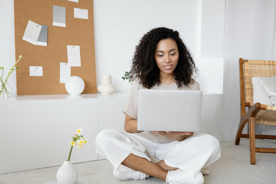 Image of a smiling woman with a laptop to illustrate learning and working remotely using strategic planning software.