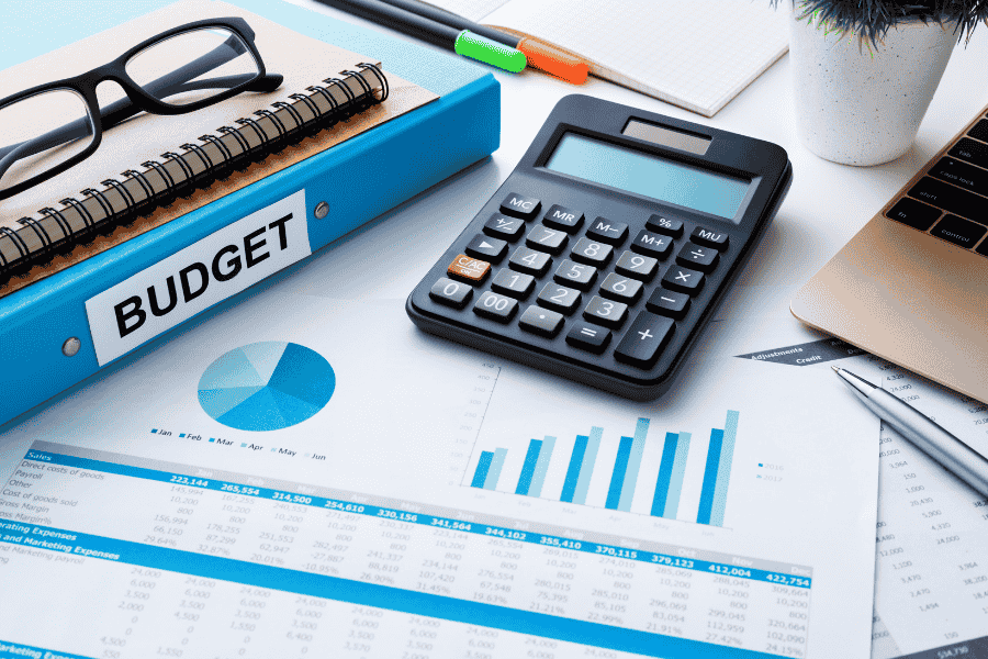 budgeting sheets with graphs, calculator, and budgeting binder
