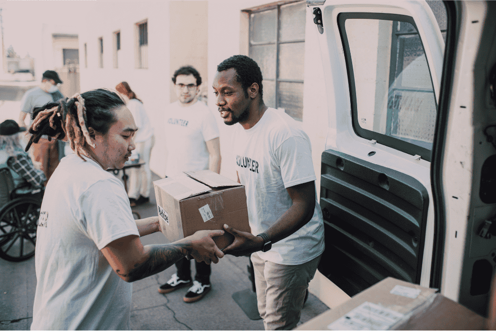 Volunteers helping carry supplies from a van
